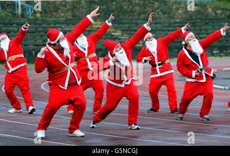 Santas si è scaldato in preparazione alla Grande Santa Run di Edimburgo che si terrà presso lo stadio Meadowbank di Edimburgo il 9 dicembre. Foto Stock