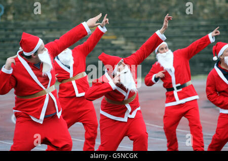 Santas si è scaldato in preparazione alla Grande Santa Run di Edimburgo che si terrà presso lo stadio Meadowbank di Edimburgo il 9 dicembre. Foto Stock