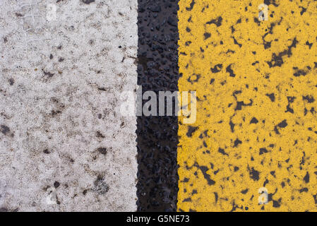 Asfalto autostrada texture con incrinato bianco e striscia gialla Foto Stock