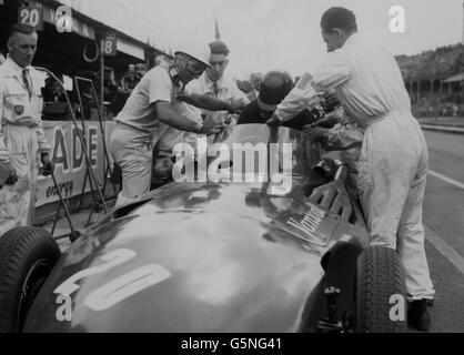 Stirling Moss sale al posto di guida della Vanwall di Tony Brooks dopo che il suo aveva sviluppato problemi durante la gara del Gran Premio d'Europa ad Aintree, Liverpool. Moss ha poi ottenuto la prima vittoria all-British in un grande classico dal 1923. Foto Stock