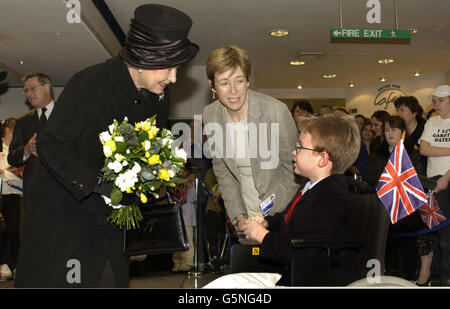 La regina britannica Elizabeth II accetta un bouquet da George Colvin-Slee, otto, che si sta riprendendo da un'operazione per allungare la gamba destra, al Great Ormond Street Hospital for Children, Londra, che celebra il suo 150° compleanno. * ... La regina è accompagnata dal direttore generale degli ospedali, il dottor Jane Collins. Foto Stock