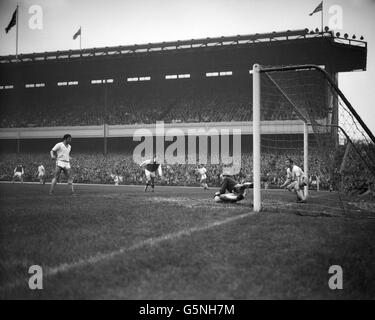 Tuffandosi sulla sfera, il portiere del Manchester United Harry Gregg fa un salvataggio spettacolare durante la prima partita di divisione contro l'Arsenal ad Highbury, Londra. Arsenal ha vinto la partita 2-1. Foto Stock