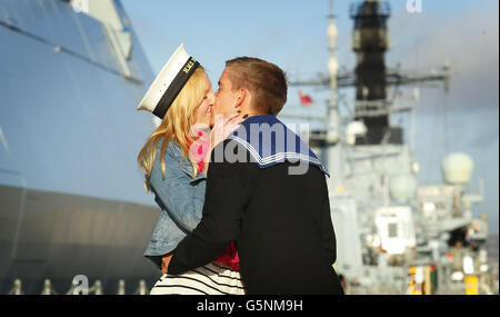 George Halsall, tecnico di ingegneria aeronautica leader, propone alla sua fidanzata Emma Davies, 21 anni, dopo il ritorno a casa per Natale a bordo del Diamond HMS alla Royal Navy base di Portsmouth. Foto Stock