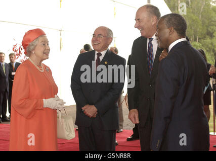 La Regina Elisabetta II della Gran Bretagna viene salutata (da sinistra) dal primo Ministro australiano John Howard, dal Segretario Generale del Commonwealth Don McKinnon e dal primo Ministro sudafricano Thabo Mbeki, quando arriva ad aprire il Commonwealth Capi di Governo Meeting a Coolum sulla Sunshine Coast Coast del Queensland, Australia. Foto Stock