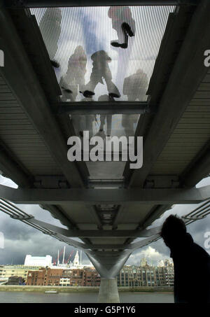 Dopo la riapertura a Londra, dopo una modifica di 5 milioni di euro, gli escursionisti controllano la presenza di eventuali vortici sul Millennium Bridge sul Tamigi. Il ponte da 18.2 milioni di persone ha subito un'oscillazione sotto il peso di migliaia di pedoni quando è stato inaugurato nel giugno 2000. * dopo soli tre giorni gli operatori del ponte dovettero chiudere la struttura lunga 320 metri, che va dalla cattedrale di St Paul a nord del Tamigi a Londra fino a Tate Modern sulla riva sud. Foto Stock