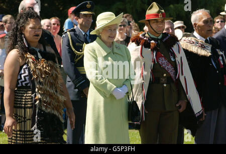 La regina Elisabetta II, accompagnata da un ufficiale dell'esercito neozelandese e da una tribeswoman Maori, è data un tradizionale benvenuto Maori al campo militare di Burnham a Christchurch, Nuova Zelanda. *la Regina e il Duca di Edimburgo avevano trascorso il fine settimana privatamente a Taupo prima che iniziassero seriamente gli impegni ufficiali per il loro tour del Giubileo d'Oro della Nuova Zelanda. Foto Stock