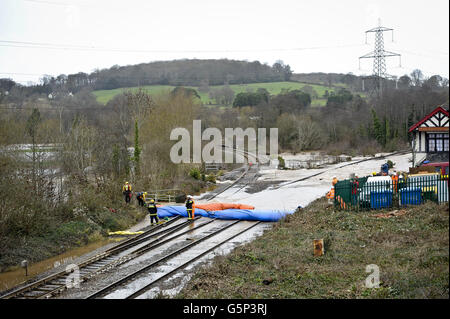 Una visione generale degli ingegneri ferroviari e del personale addetto ai servizi antincendio e di soccorso da parte delle dighe gonfiabili sulla linea ferroviaria di Cowley Bridge, vicino a Exeter, Devon, nel tentativo di arginare il flusso d'acqua dove la pista si è allagata e ha causato danni strutturali, chiudendo le linee nel corso di Natale. Foto Stock