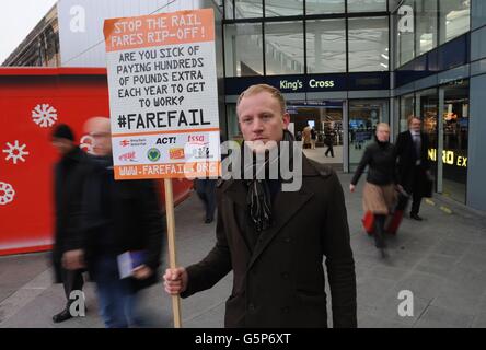 Un attivista ferroviario dimostra al di fuori della stazione King's Cross di Londra come le tariffe regolamentate, che includono i biglietti stagionali, sono aumentate in media del 4.2%, con un aumento medio di tutte le tariffe pari al 3.9%. Foto Stock