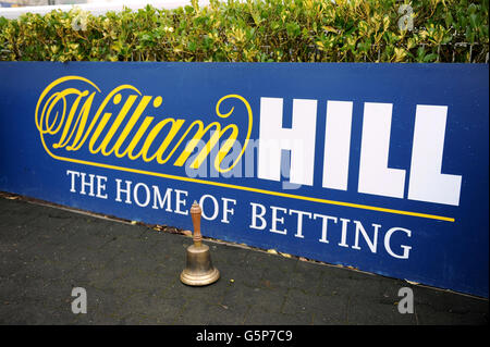 Corse di cavalli - William Hill Winter Festival - giorno due - Ippodromo di Kempton Park. Dettaglio di un campanile di un impiegato seduto sul pavimento di fronte alla segnaletica di William Hill Foto Stock