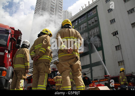 Hong Kong, Cina. Il 22 giugno, 2016. Vigili del fuoco lavoro presso il sito di un incendio a Hong Kong, Cina del Sud, 22 giugno 2016. Un vigile del fuoco è stato ucciso in un incendio mortale che scoppiò il martedì mattina in un multipiano di edificio industriale in Hong Kong Kowloon East area. Altri sette vigili del fuoco sono stati feriti quando combatte il blaze, che è stato è durato per più di ventiquattro ore. Credito: Wang Shen/Xinhua/Alamy Live News Foto Stock