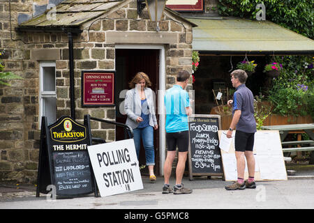 L eremita, un villaggio pub di Burley Woodhead, West Yorkshire, Gran Bretagna. Il 23 giugno, 2016. In procinto di esprimere il loro voto, un paio di uomini sono arrivati a questo referendum UE stazione di polling e sono in piedi indietro, in attesa di un altro elettore (una donna) di entrare attraverso la porta prima. Credito: Ian Lamond/Alamy Live News Foto Stock