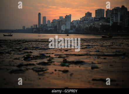 Vista generale della spiaggia di Chowpatty mentre il sole tramonta dietro le colline di Malaba (il Manhatton di Mumbai) a Mumbai, India Foto Stock