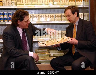 Lo chef Marco Pierre White (a sinistra) e John, l'undicesimo Conte di Sandwich, si infilano nei sandwich durante il lancio della gamma Earl of Sandwich a Fortnum and Masons a Londra. I lussuosi panini freschi saranno disponibili nei grandi magazzini. Foto Stock