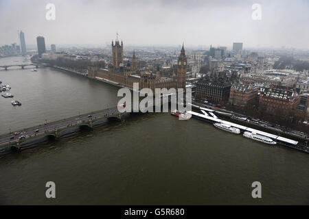 1000 persone hanno sfidato le condizioni meteorologiche avverse al EDF Energy London Eye questa mattina, accodandosi nella neve per la riapertura dell'"Lift London" e per una rotazione libera. Foto Stock