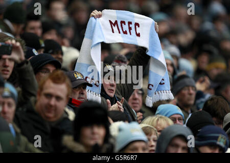 Calcio - Barclays Premier League - Manchester City v Fulham - Etihad Stadium. Un fan di Manchester City tiene in piedi una sciarpa Foto Stock