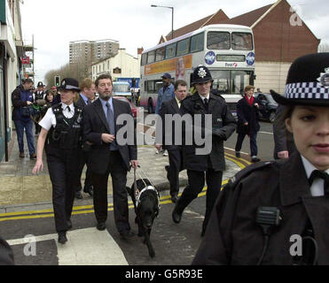 Il segretario all'interno David Blunkett (al centro) è aiutato dall'ispettore di settore Jeanette Harris durante la sua visita ai negozianti di Stapleton Road, Bristol, * il giorno stabilito nuove linee guida stop-and-search che sono progettate per contribuire a ripristinare la fiducia nel modo in cui la polizia si occupa delle minoranze etniche. Le nuove misure faranno sì che tutti i poliziotti si fermeranno con un certificato che spiegheranno perché sono stati fermati. Foto Stock