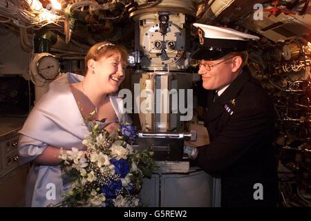 Il Chief Petty Officer Chris Tandy e la moglie Eva di Plymouth che si sposò a bordo di un sottomarino a Gosport, Hampshire. La cerimonia vide il sottomarino legare il nodo con la sua fidanzata Eva driver, sulla HMS Alliance al Royal Navy Submarine Museum. Foto Stock