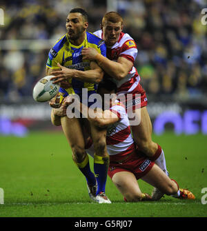 Ryan Atkins di Warrington Wolves viene affrontato da Wigan Warriors Jack Hughes (lerft) e Matty Smith durante la partita della Super League al DW Stadium di Wigan. Foto Stock