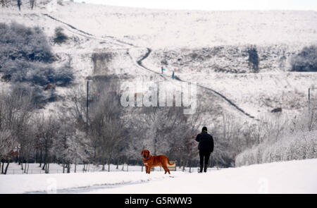 Un uomo cammina oggi il suo cane nel parco di Herrington Country vicino Sunderland mentre il freddo scatto continua a colpire il Regno Unito. Foto Stock