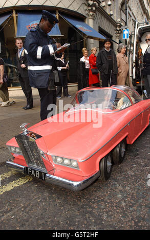 Un operaio di traffico prende un interesse in Lady Penelope e il suo maggiordomo Parker, da Thunderbirds, con la FAB 1 auto fuori Planet Hollywood, centro di Londra. I burattini fanno parte dell'asta del film e dell'intrattenimento 'at the Movies'. *... Si prevede che il burattino Lady Penelope recupererà almeno 20,000 con Parker e FAB1 rosa Rolls Royce che guida stimato a 15,000 ciascuno. Foto Stock