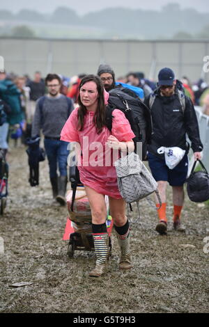 Festivalgoers arriva per il festival di Glastonbury presso l'azienda agricola degna sito, Somerset, dove la pioggia pesante per un periodo di tempo prolungato ha causato inondazioni isolato e campi fangosi. Foto Stock