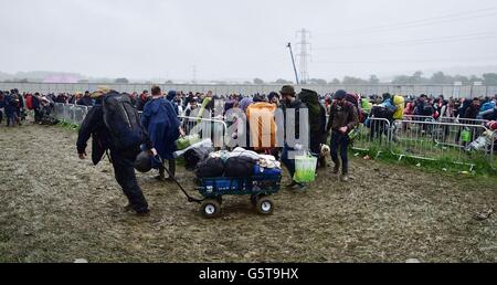 Festivalgoers arriva per il festival di Glastonbury presso l'azienda agricola degna sito, Somerset, dove la pioggia pesante per un periodo di tempo prolungato ha causato inondazioni isolato e campi fangosi. Foto Stock