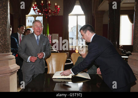 Il Principe di Galles (a sinistra) ride mentre la Duchessa di Cornovaglia firma il libro dei visitatori mentre il Direttore Generale Kevin Kelly (a destra) guarda durante una visita al recentemente rigenerato St Pancras Renaissance London Hotel adiacente alla Stazione Internazionale St Pancras di Londra, che segnano 150 anni Metropolitana di Londra. Foto Stock