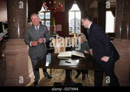 Il Principe di Galles (a sinistra) ride mentre la Duchessa di Cornovaglia firma il libro dei visitatori mentre il Direttore Generale Kevin Kelly (a destra) guarda durante una visita al recentemente rigenerato St Pancras Renaissance London Hotel adiacente alla Stazione Internazionale St Pancras di Londra, che segnano 150 anni Metropolitana di Londra. Foto Stock