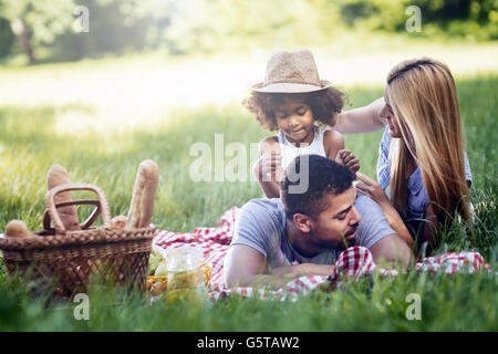 Famiglia pic-nic all'aperto con la loro figlia carino Foto Stock