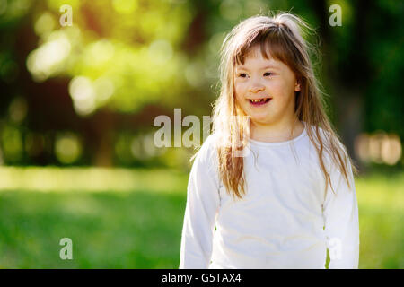 Bellissimo bambino felice affetti da sindrome di Down sorridente all'aperto Foto Stock