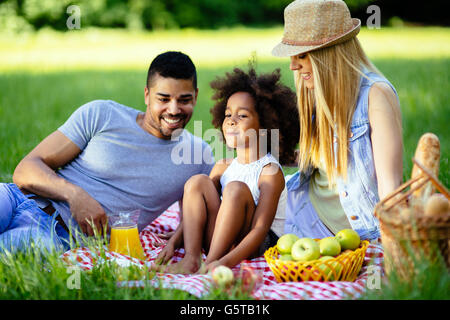 Famiglia pic-nic all'aperto con la loro figlia carino Foto Stock