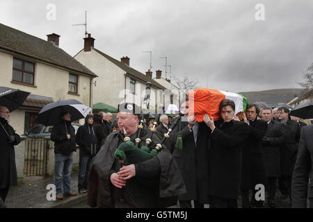 La bara di Dolours Price viene trasportata dalla sua casa di famiglia Slievegallion Drive ad Andersontown West Belfast dai suoi due figli Danny e Oscar davanti e il suo ex attore partner Stephen Rea (dietro a destra) alla chiesa di Sant'Agnese e poi sul cimitero di Milltown per la sepoltura. Foto Stock