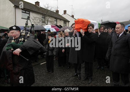 La bara di Dolours Price viene trasportata dalla sua casa di famiglia Slievegallion Drive ad Andersontown West Belfast dai suoi due figli Danny e Oscar davanti e il suo ex attore partner Stephen Rea (dietro a destra) alla chiesa di Sant'Agnese e poi sul cimitero di Milltown per la sepoltura. Foto Stock