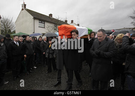 La bara di Dolours Price viene trasportata dalla sua casa di famiglia Slievegallion Drive ad Andersontown West Belfast dai suoi due figli Danny e Oscar davanti e il suo ex attore partner Stephen Rea (dietro a destra) alla chiesa di Sant'Agnese e poi sul cimitero di Milltown per la sepoltura. Foto Stock