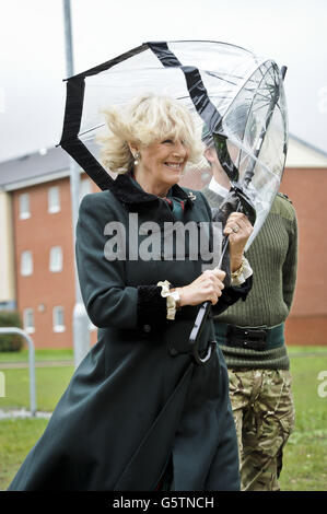 L'ombrello della Duchessa di Cornovaglia si piega nel vento quando arriva all'Hub a Ward Barracks, campo di Bulford durante una visita al 4° Battaglione, i Rifles, nel Wiltshire. Foto Stock