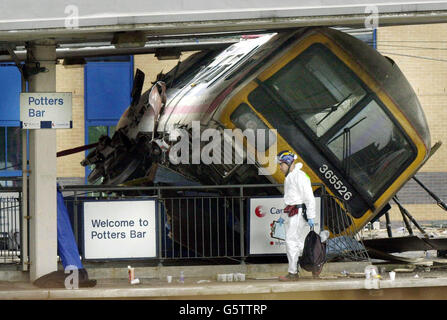 Treno Crash - Hertfordshire. Un investigatore di crash cammina vicino alla scena del crash ferroviario alla stazione Potter's Bar, Hertfordshire. Foto Stock