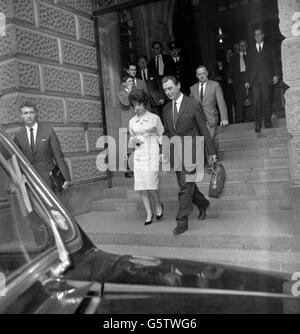 Il dottor Stephen Ward, accompagnato da Julie Gulliver, sta portando con sé una piccola stalla in tela, a Londra dopo aver dato le prove dalla scatola dei testimoni il quarto giorno del suo processo presso l'Old Bailey. Foto Stock