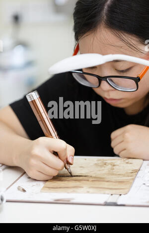 Una ragazza asiatica nella pratica del sopracciglio Foto Stock