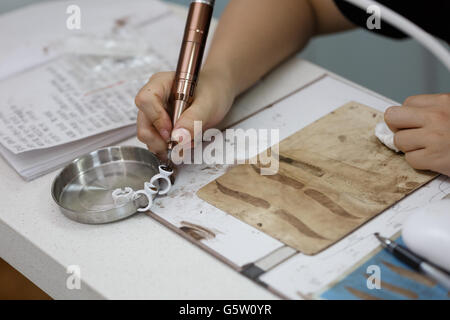 Una ragazza asiatica nella pratica del sopracciglio Foto Stock