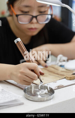 Una ragazza asiatica nella pratica del sopracciglio Foto Stock