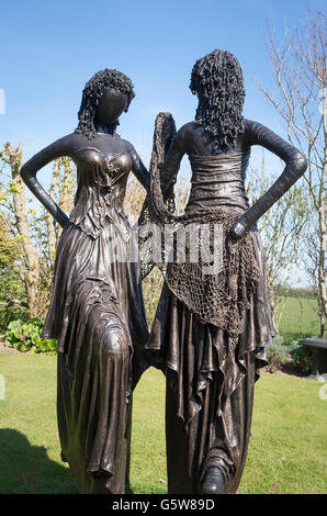 Scultura da giardino dotato di due giovani donne in abiti in un piccolo Cornish gardenot vicino a Truro Foto Stock