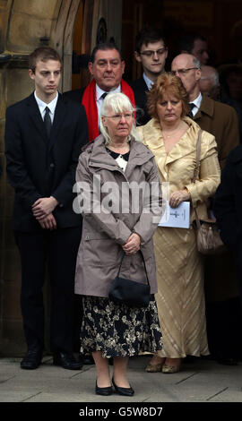 Maureen Greaves, centro anteriore, moglie di Alan Greaves, 68, guarda il suo barin mariti lasciare la chiesa di San Salvatore in High Green, Sheffield, dopo il suo funerale. Foto Stock