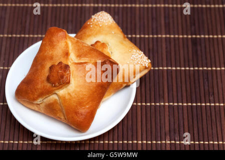 Due pasties ripiene di carne in bambù igienico, close up Foto Stock