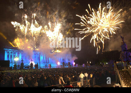 I fuochi d'artificio scoppiarono su Buckingham Palace a Londra, dopo che la Regina Elisabetta II della Gran Bretagna illuminò un faro per commemorare il suo Giubileo d'oro. * in precedenza, circa 12,000 persone avevano guardato il Party in the Palace - il secondo concerto che si terrà nei giardini in tre giorni - una folla stimata in un milione di persone si era riunita all'esterno per godersi la musica. Martedì si recherà al San Paolo per un servizio di ringraziamento. Foto Stock