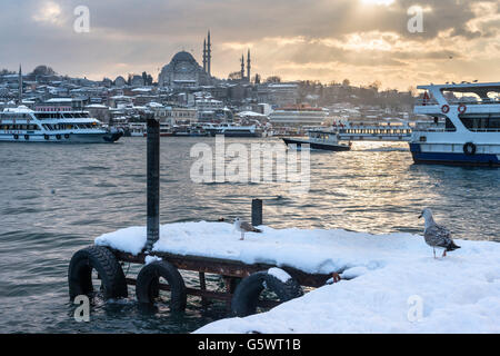 Coperta di neve Karakoy waterfront, guardando attraverso il Golden Horn verso l'sulimaniye moschea e la skyline di Istanbul. Istanbul Foto Stock