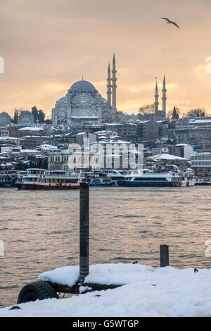 Coperta di neve Karakoy waterfront, guardando attraverso il Golden Horn verso l'Sulimaniye moschea e la skyline di Istanbul. Istanbul Foto Stock