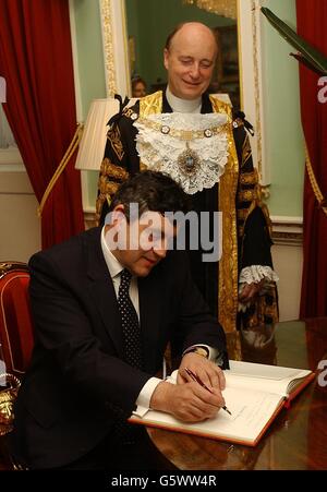 Il Cancelliere dello scacchiere, Gordon Brown, firma il libro dei visitatori, con Lord Mayor, Alderman Michael Oliver, sullo sfondo, alla Mansion House, Londra. Stava frequentando e parlando alla cena del sindaco del Signore ai banchieri ed ai mercanti della città di Londra. Foto Stock