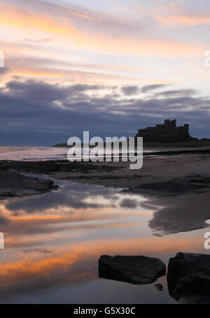 FOTO STANDALONE. Alba sopra il Castello di Bambburgh, Northumberland. Foto Stock