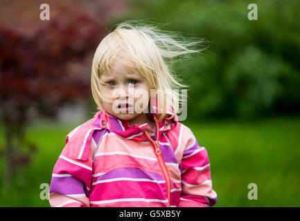 Triste o disorientati ragazza in piedi da solo in giardino Foto Stock