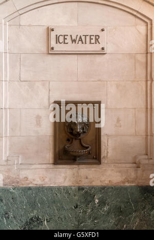 Acqua ghiacciata fontana al Hoboken rail terminal New Jersey nella forma di un leone di bronzo testa su una parete di marmo Foto Stock